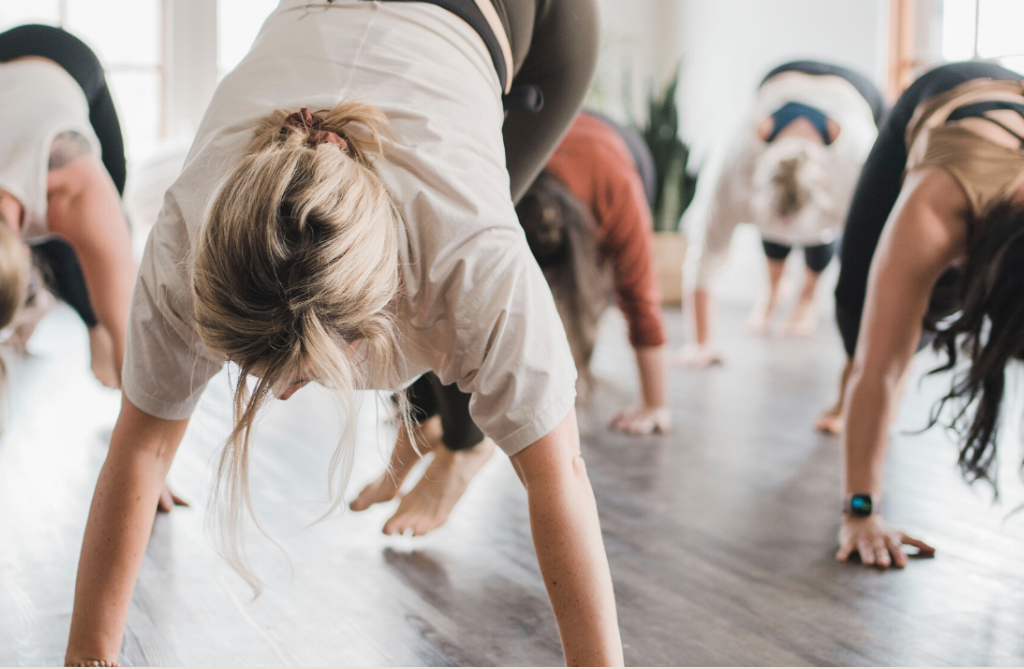 groupe de personnes qui font du yoga dans une salle intérieure